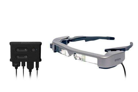 Wearable device resembling a pair of narrow goggles. The device is medium-grey in color. Also shown is a control panel with four different plugs.