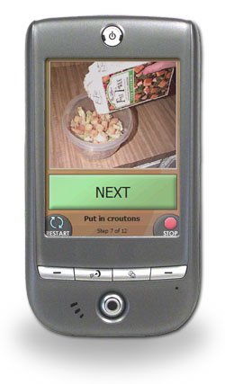 Small handheld phone with display showing an image of milk being poured into a cereal bowl.