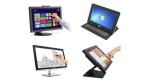 Various models of touchscreen computer monitors. They resemble medium to small-sized standard computer monitors. Two of the images show a user operating them with their finger. One is using a stylus to draw directly on the monitor. The monitors feature built-in stands, one of which is angled upwards and backwards slightly. Three monitors are black, and one is silver with a black frame.